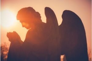 statue of an angel lit by the setting sun