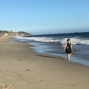 author Bryn Donovan walking on a sunny beach