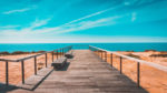 beach; boardwalk leading to a calm sea