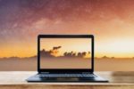 IMAGE: laptop reflecting the sunrise and clouds behind it Writing Motivation: 12 Positive Affirmations for Writers #affirmations for writer's block #encouragement for writers