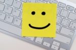 post-it with smiley face on keyboard