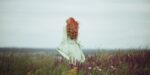 woman in white gown with long red hair near the ocean - medieval names for women