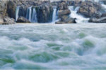 waterfalls falling into a rushing stream