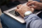 hands of author over 60 on laptop writing