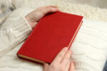 woman holding red books