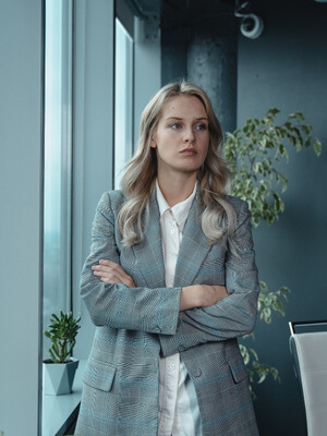 businesswoman with angry expression standing at window