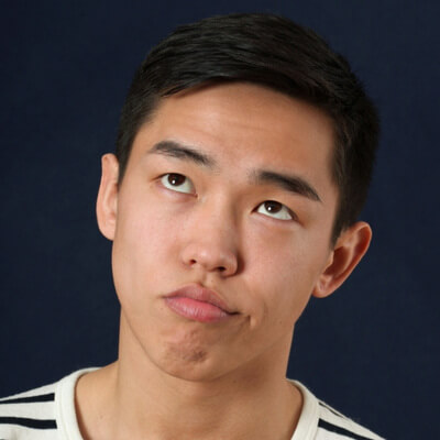 young asian man with annoyed expression rolling his eyes