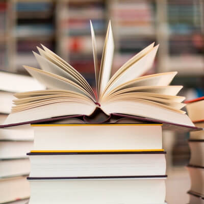 stack of books, one open - can you start a novel with dialogue