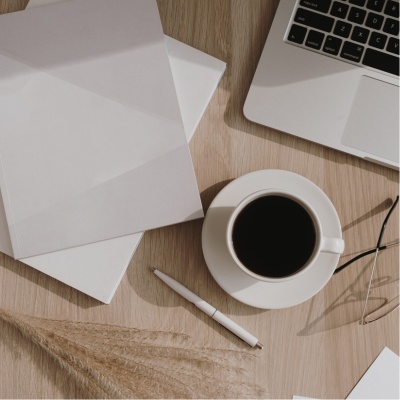 papers, coffee, a pen, and a laptop keyboard