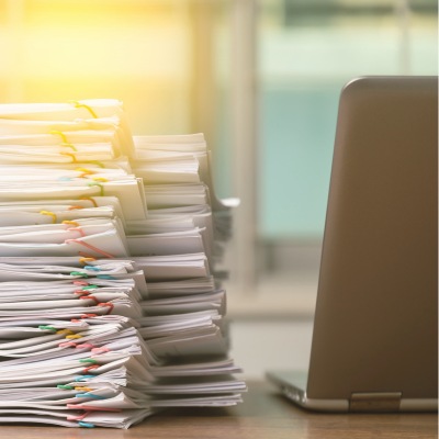 laptop and stacked novel manuscripts