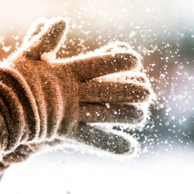 gloved hands brushing off snow