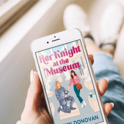 someone holding an iPhone with the book cover for HER KNIGHT AT THE MUSEUM by Bryn Donovan