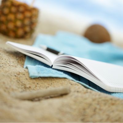 closeup of journal and pen on sand