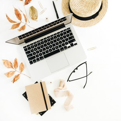 laptop, leaves, journal, glasses, straw hat