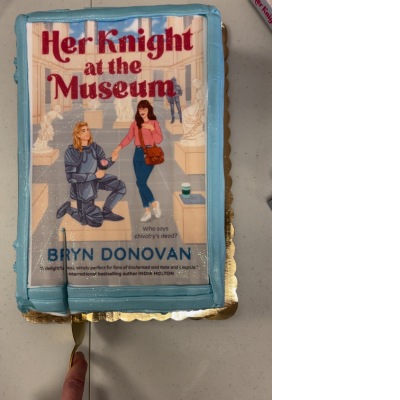 cake with the book cover design for Her Knight at the Museum on the top